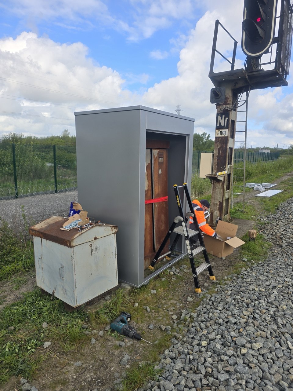 Engineer assembling the anti-vandal enclosure around the existing cabinet